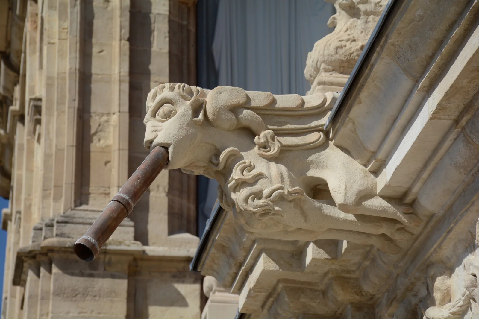 Detalle de gárgola de piedra en una fachada histórica